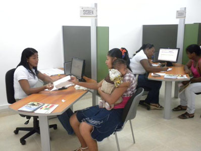 A De Una staffer helps a mother fill out paper work to receive benefits.