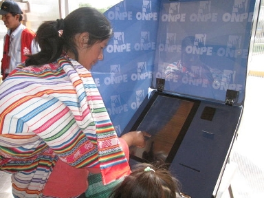 A woman practices casting her ballot on an e-voting simulator.