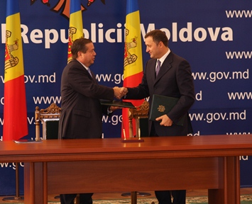 Prime Minister Filat (right) and Nix shake hands after signing the memorandum of understanding.