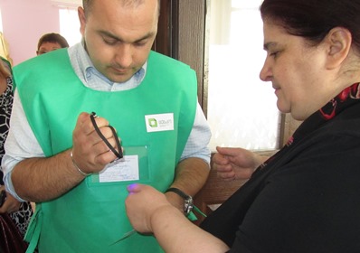 A poll worker checks a voter’s finger for ink during Georgia’s October 2012 parliamentary elections.