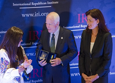 Sen. McCain shows the Order of the Defense of the Euromaidan medal to Ruslana as Sen. Ayotte looks on.