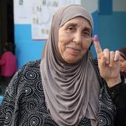 A woman in Tunis holds up her finger showing she has voted in the election. 