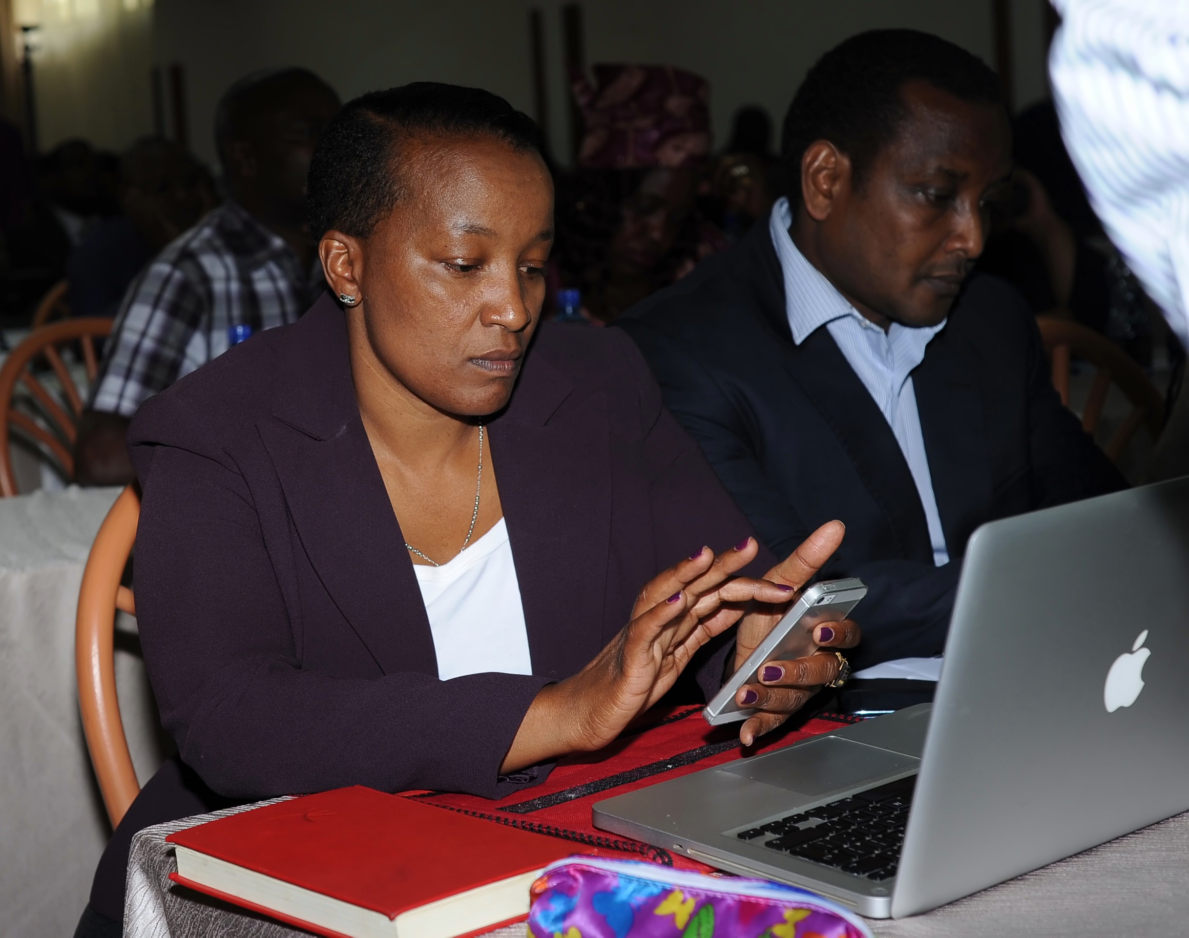 Roselyn Mungai, the chief executive officer of CAF, tests out the SMS system.