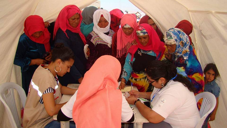 Rural women pick up literature about municipal elections from volunteers at a traveling health caravan event in Essabala, Sidi Bouzid. 