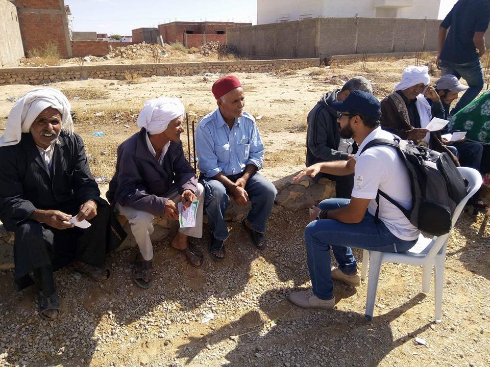 A young volunteer in Essabala, Sidi Bouzid,  asks a group of older men what local government means for them. 