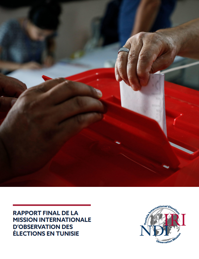A hand places a ballot into a ballot box