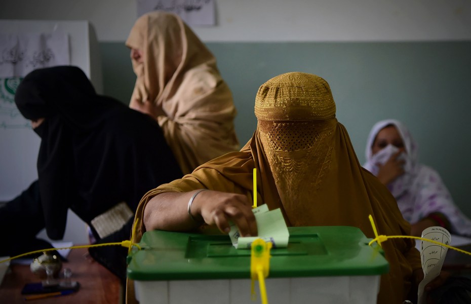 A burqa-clad woman casts her vote during Pakistan's general election