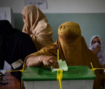 A burqa-clad woman casts her vote during Pakistan's general election