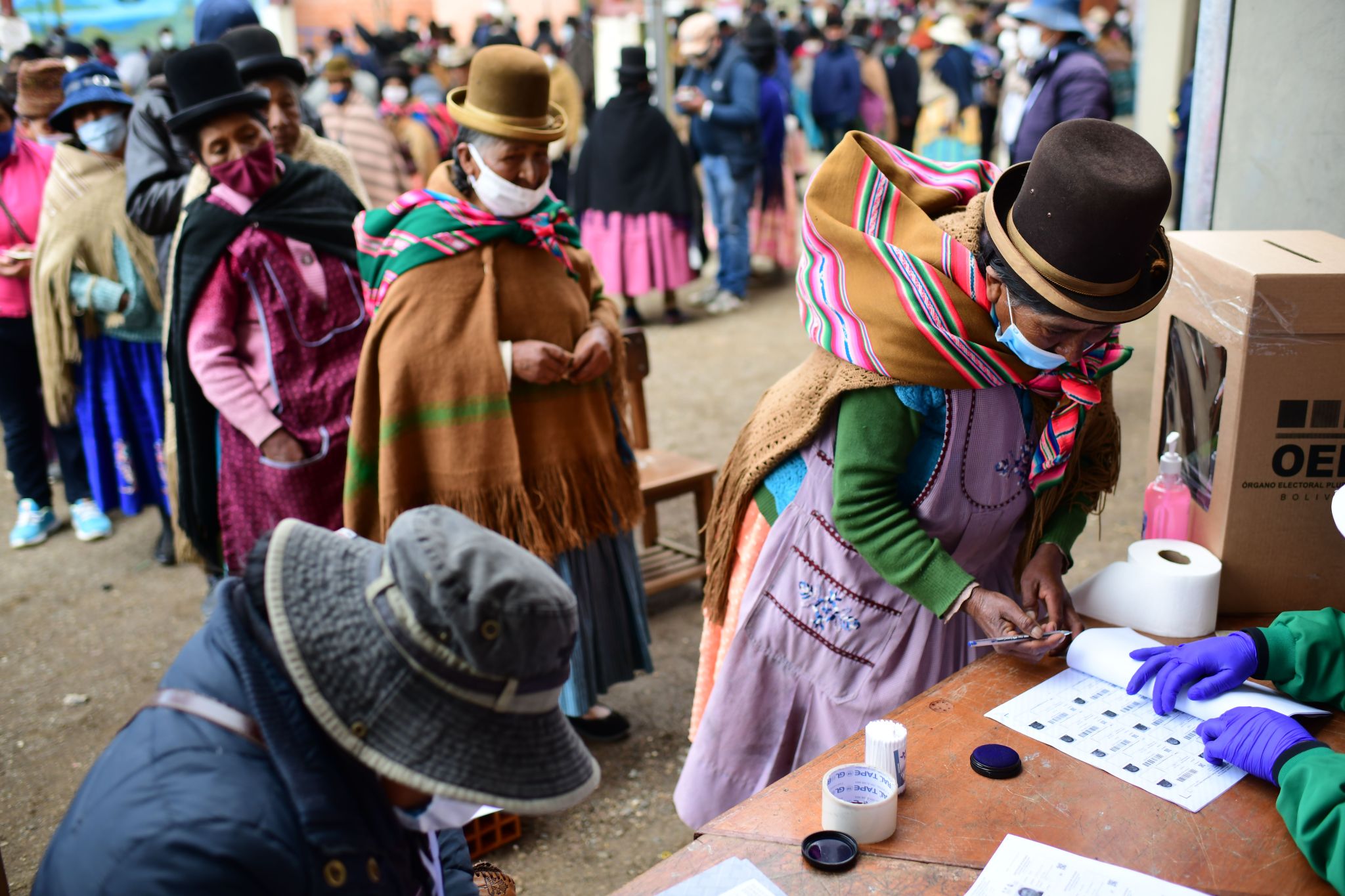 An indigenous woman signs after casting her vote