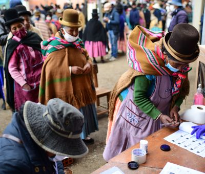 An indigenous woman signs after casting her vote