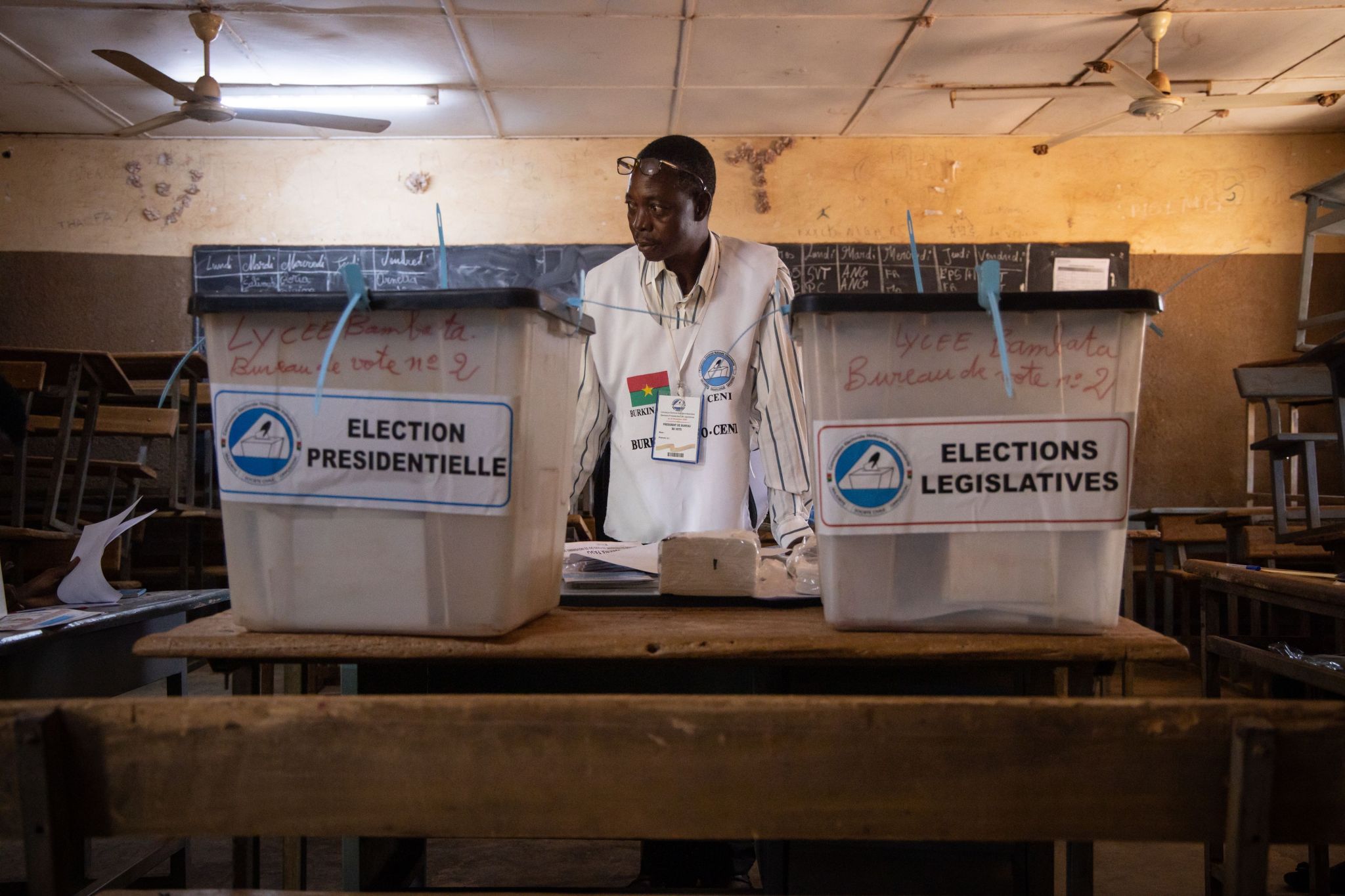 A man stands in-between two ballot boxes