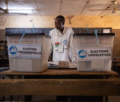 A man stands in-between two ballot boxes