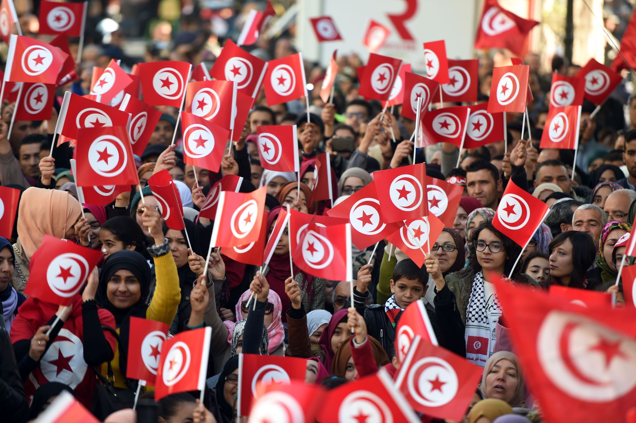 Tunisians wave national flags