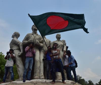 A few people gather on a statue in Bangladesh for a student demonstration