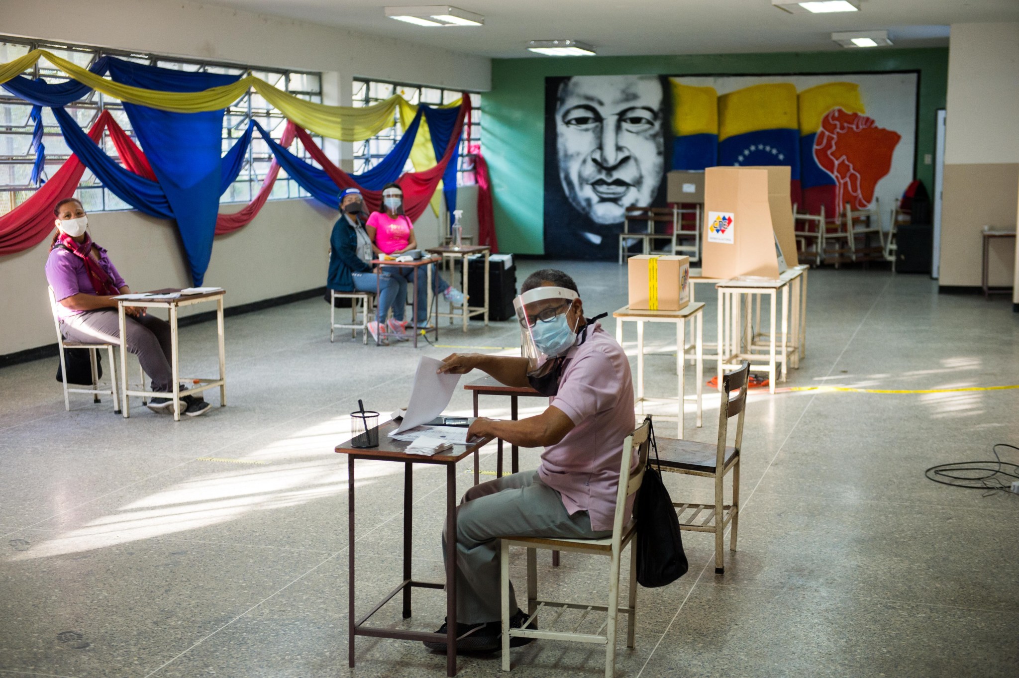 A few people sit at desks to monitor elections in Venezuela