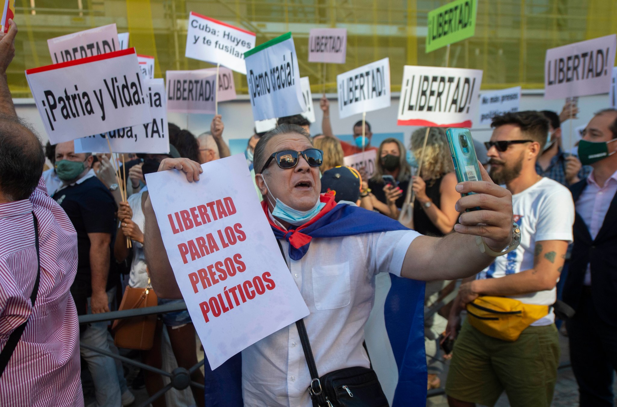 A group holds up signs in Cuba, protesting for freedom