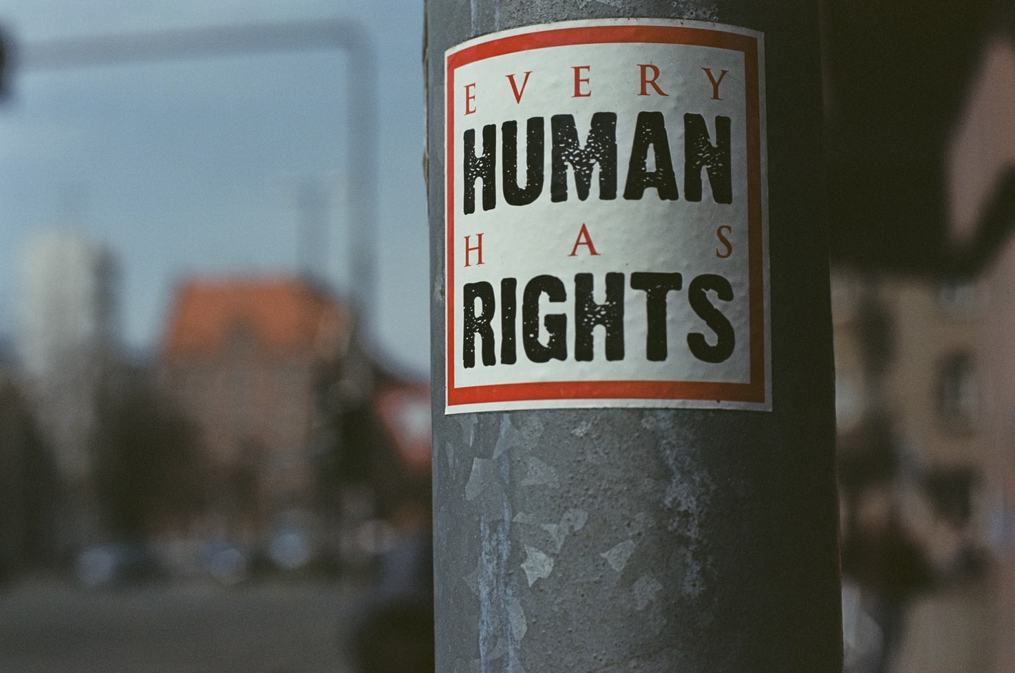 A sticker on a pole advocates for human rights