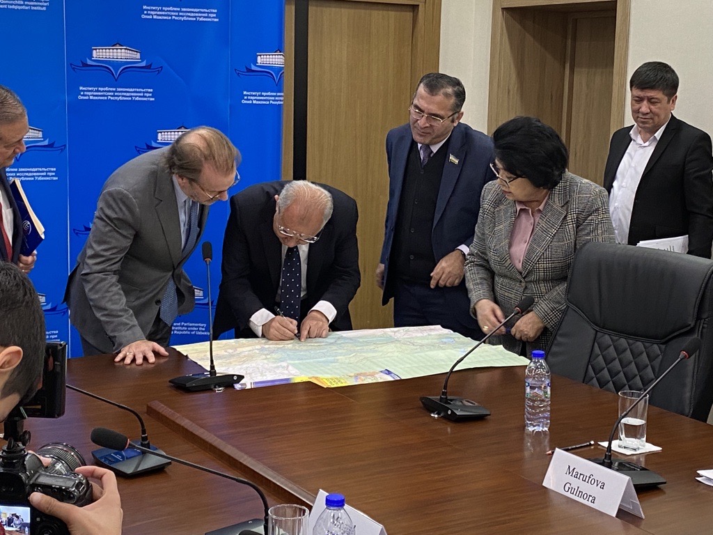 People gather around a table looking at map
